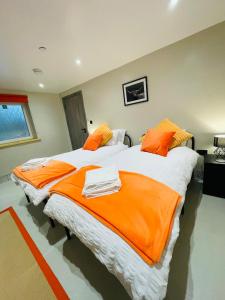 卡马森Barnaby’s Barn的配有橙色床单的客房内的两张床