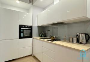 格但斯克White Apartment的白色的厨房配有白色橱柜和水槽