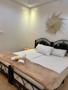 阿加迪尔rise surf and yoga morocco的卧室配有一张带白色床单和枕头的大床。