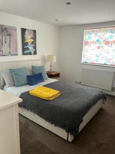 AshfordGorgeous Cosy home 2 Miles from Heathrow Airport的一间卧室配有一张黄色毯子床