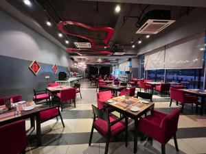 莎阿南Best Western i-City Shah Alam的一间餐厅,房间内设有红色的椅子和桌子