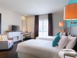 莎阿南Best Western i-City Shah Alam的酒店客房设有一张大床和一张书桌。