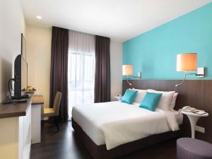 莎阿南Best Western i-City Shah Alam的酒店客房设有一张大床和一张书桌。