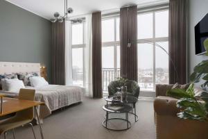 卡尔斯塔德Best Western Hotel River C的一间卧室配有一张床、一张沙发和一张桌子