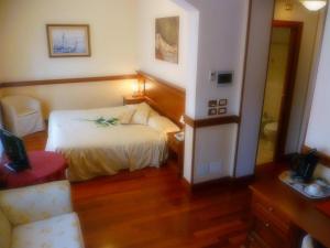 波代诺内米内尔瓦酒店的一间卧室配有一张床和一把椅子