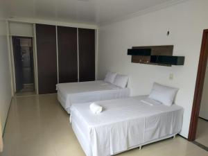 维索萨-杜塞阿拉VIVENDA JUAREZ的配有白色床单的酒店客房内的两张床
