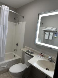 梅德福梅德福戴斯酒店的一间带卫生间、水槽和镜子的浴室