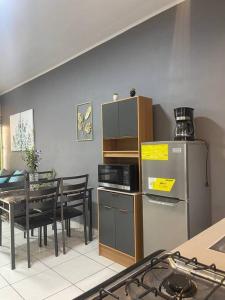 科马亚瓜Casa Residencial Quinta的厨房配有桌子和不锈钢冰箱。
