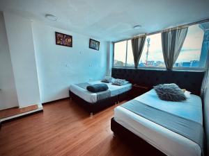 波哥大Bogotá Elite的酒店客房设有两张床和窗户。