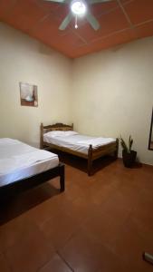 里瓦斯Hostal Casa Bonita Ometepe的客房设有两张床和吊扇。