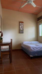 里瓦斯Hostal Casa Bonita Ometepe的一间卧室配有两张床、一张桌子和吊扇。