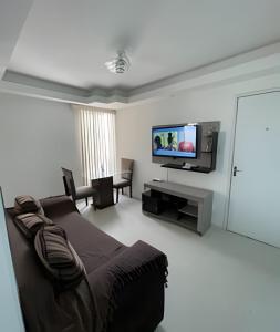 费拉迪圣安娜Aconchego Urbano: Espaçoso C/Ar的客厅配有床和平面电视