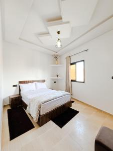 达赫拉Hotel Ahmed Ali的白色的卧室设有床和窗户