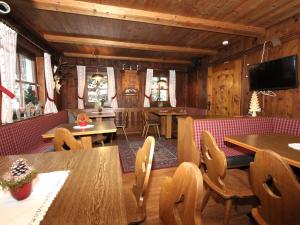 迈尔霍芬Alpenhaus Lacknerbrunn的用餐室设有木墙和桌椅