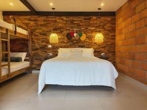 贾丁Gulupa Ecolodge的一间卧室设有一张床和砖墙