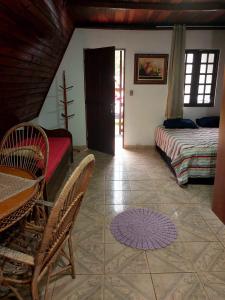 萨利索波利斯Chalé Pousada em Salesopolis 7的卧室配有一张床和一张桌子及椅子