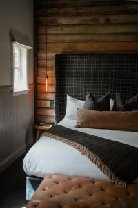 卡德罗纳卡德罗纳酒店的一间卧室设有一张带木墙的大床