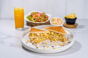 波托维耶霍Hotel Paraiso的盘子,上面有三明治,沙拉和一杯橙汁
