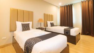 达沃市Asrodel Hotel RedPartner的一间酒店客房,房间内设有两张床