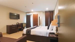 达沃市Asrodel Hotel RedPartner的配有一张床和一张书桌的酒店客房