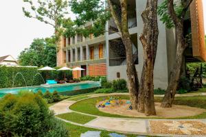 清迈Proud Phu Fah Muang Chiang Mai的公寓大楼设有游泳池和花园