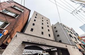 首尔H Hotel Wangsimni的一座高大的砖砌建筑,上面有标志