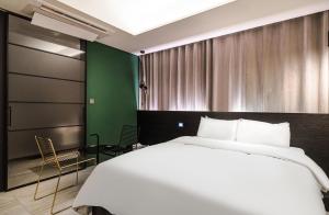 首尔H Hotel Wangsimni的卧室设有一张白色大床和绿色的墙壁