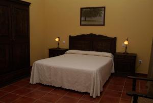 特鲁希略卡萨拉斯维坎特拉斯酒店的卧室配有一张床,墙上有两盏灯