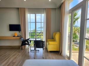 富国Hi Beach House Phu Quoc - Sunset Town的一间卧室配有黄色的沙发、桌子和椅子