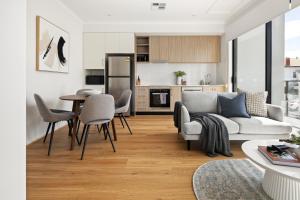 Port AdelaideClare St Apartments by Urban Rest的客厅配有沙发和桌椅