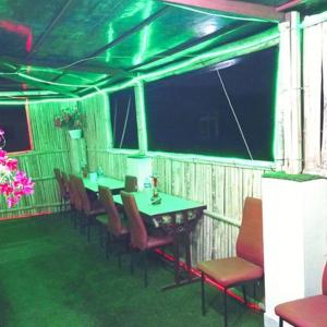 加德满都Hotel Times的一间带桌椅和绿灯的用餐室