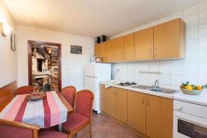 伊格拉恩Secluded holiday house Zivogosce - Mala Duba, Makarska - 19811的厨房配有桌子和白色冰箱。