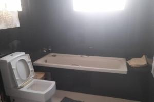 罗安达Casa de Amor的浴室配有白色卫生间和浴缸。