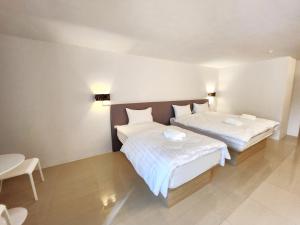 曼谷Prom Ratchada Hotel - SHA Plus的配有白色床单的客房内的两张床