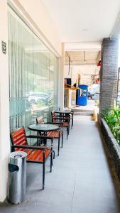 巴淡岛中心OS Hotel Batu Aji Batam的建筑物里的一排桌子和长椅