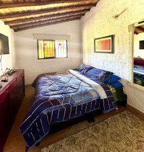 瓜尔内La Colina Magik的一间卧室配有一张床、梳妆台和窗户。