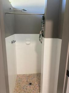 Woodburn罗利伍德伯恩汽车旅馆 的一间铺有瓷砖地板的带淋浴的浴室