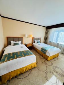 乌兰巴托Flower Hotel Ulaanbaatar的大型客房设有2张床和窗户。