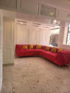 斯利那加HOTEL K2 INN , Srinagar的客厅里红色的沙发,配有黄色枕头