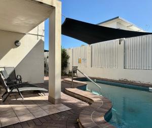 汤斯维尔Townsville Lighthouse - 3/103 Strand的庭院设有游泳池、桌子和椅子