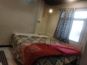 乌贾因New G P Guest house的一间小卧室,配有床和窗户
