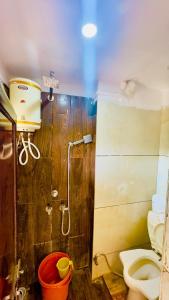 乌贾因New G P Guest house的带淋浴、卫生间和桶的浴室