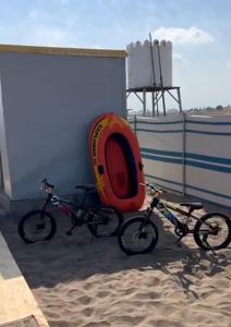 拜尔卡Dolphin Campground的两辆自行车停放在海滩上一座建筑旁边