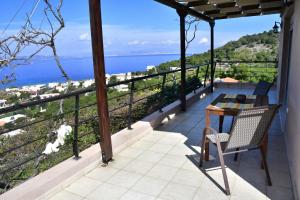 阿吉亚玛丽娜Sanctuary Villa in Vagia, Aegina的阳台配有桌子,享有海景。