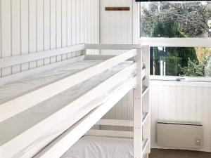 米泽尔法特Holiday home Middelfart IV的窗户客房内的一张白色双层床