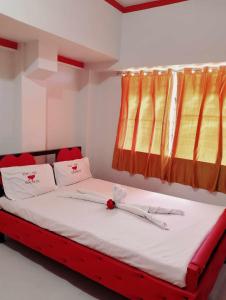 巴科洛德WJV INN BACOLOD的红色和黄色窗帘的房间的一张床位