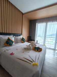 龙目岛库塔Raja Hotel Kuta Mandalika Resort & Convention的一间卧室配有一张白色大床,床上有鲜花