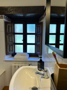 阿里纳斯·德·卡伯瑞勒斯Casa Arenas的一间带水槽的浴室和两个窗户