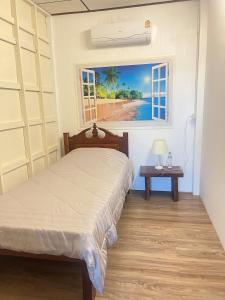 碧差汶At Home Phetchaboon的一间卧室配有一张床,享有海滩美景