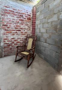 里瓦斯Hostal Brisas del Ometepe的砖墙中的摇椅